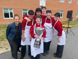 Coventry Oakers and Commissioner Infante-Green pose with the Governor's Cup trophy after winning the Menu for Success Student Food Truck Roundup