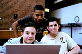 Students sitting in front of a laptop